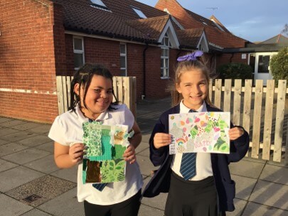 Photo of two pupils proudly showing their work